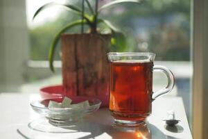 temprano Mañana verde té y azúcar en mesa cerca ventana foto