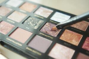 A palette with eye shadows and a makeup brush . photo