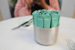 white sugar in a paper packet on table photo