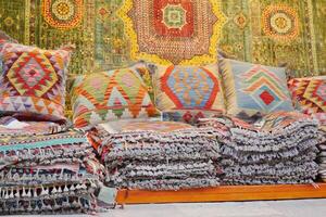 Colourful cushions and carpet on display for sale in a traditional Turkish Bazaar. photo