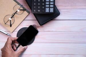 charging Smartphone Using Wireless Charging Pad, top view photo
