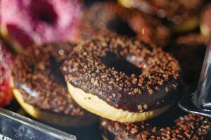 chocolate donuts display for sale at local store photo