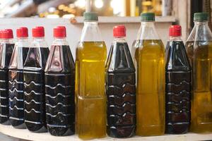 Several bottles of oil arranged on a table for food storage photo