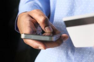 Man holding credit card and using smart phone, online shopping concept photo