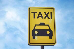 de cerca foto de un amarillo Taxi estar firmar adjunto a un metal polo