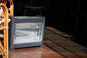 Modern electric infrared heater in living room, closeup photo