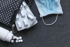 top view of pills , blister pack and face mask on table photo