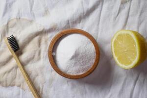 Baking soda and whole lemon on table photo