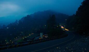 vistoso noche ligero caminos en la carretera con bosque antecedentes en puncak bogor Indonesia foto