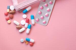 colorful pills and blister pack on pink background photo