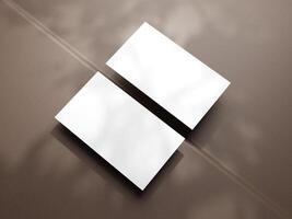 Closeup of empty white rectangle business card mockups lying diagonally on brown background. Flat lay, top view. Open composition. Blank Template for Corporate Identity. Copy space. photo