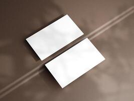 Closeup of empty white rectangle business card mockups lying diagonally on brown background. Flat lay, top view. Open composition. Blank Template for Corporate Identity. Copy space. photo