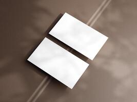 Closeup of empty white rectangle business card mockups lying diagonally on brown background. Flat lay, top view. Open composition. Blank Template for Corporate Identity. Copy space. photo