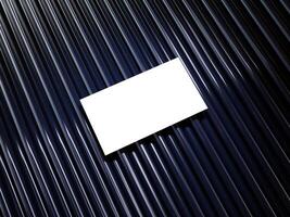 Closeup of empty white rectangle business card mockups lying diagonally on metallic blue background. Flat lay, top view. Open composition. Blank Template for Corporate Identity. Copy space. photo