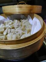 Steaming dim sum shumai in a bamboo basket photo