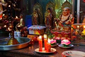 Votive candles and incense, with Buddha photo