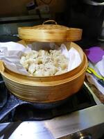 Steaming dim sum shumai in a bamboo basket photo