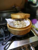 Steaming dim sum shumai in a bamboo basket photo