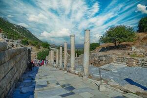 Tourists walk down the Street of Curetes towards the Library of Celsus photo