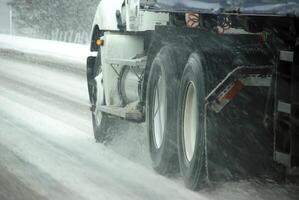 Speeding truck wheels on icy road photo