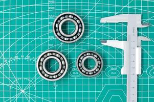 Measure caliper and roller bearings on cutting mat photo