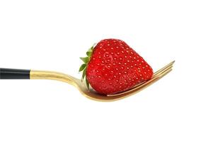 Fresh strawberry on gold fork isolated on white background photo