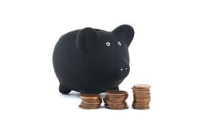 Black piggy bank and stacks of coins isolated on white photo