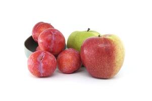 Red plums and green apple isolated on white background photo