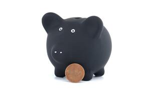 Black piggy bank and coins isolated on white background photo