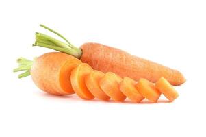 Whole carrot alongside its sliced pieces over white background photo