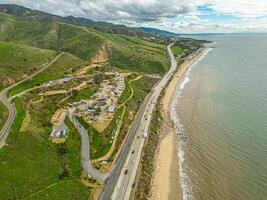 Highway Route 1 California. Aerial Panorama of the coastline and road. Green hills and beach on side photo