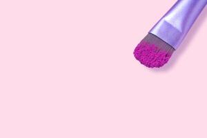 cosmético cepillos con rosado polvo en ligero rosado fondo, sitio para texto foto