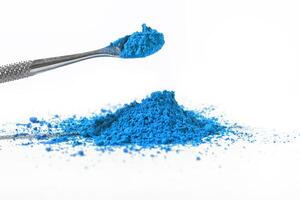 blue pigment, dry paint on a white background, macro photo
