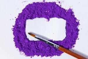 a bunch of dry natural purple pigment on a white background macro photo