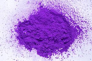 a bunch of dry natural purple pigment on a white background macro photo