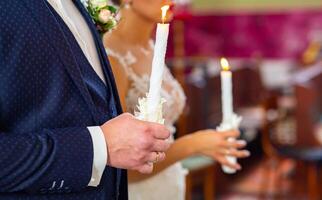 Bride and groom holding the candles. Close up. photo