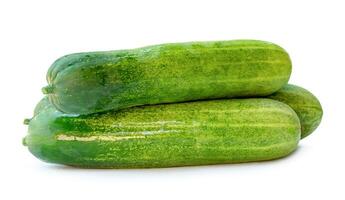 Side view of fresh green cucumbers in stack isolated on white background with clipping path photo