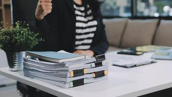 Aziatische zakenvrouw die een laptopcomputer gebruikt en op kantoor werkt met een rekenmachinedocument op het bureau, planning analyseert van het financiële rapport, businessplaninvestering, financiële analyseconcept. video