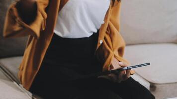 Asian woman entrepreneur busy with her work in the office. Young Asian woman work on desk laptop phone while planning sales, research or financial strategy in company video