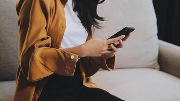 Asian woman entrepreneur busy with her work in the office. Young Asian woman work on desk laptop phone while planning sales, research or financial strategy in company video