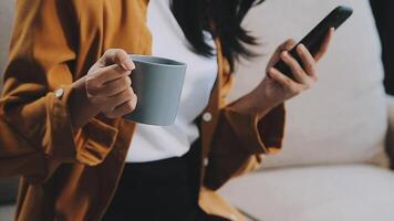 Asian woman entrepreneur busy with her work in the office. Young Asian woman work on desk laptop phone while planning sales, research or financial strategy in company video