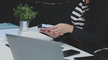 Asian Businesswoman Using laptop computer and working at office with calculator document on desk, doing planning analyzing the financial report, business plan investment, finance analysis concept. video