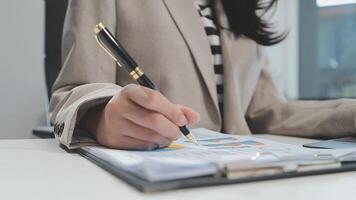 Asian Businesswoman Using laptop computer and working at office with calculator document on desk, doing planning analyzing the financial report, business plan investment, finance analysis concept. video