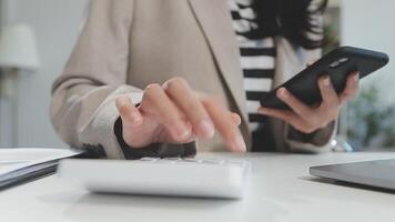 femme d'affaires asiatique utilisant un ordinateur portable et travaillant au bureau avec un document de calculatrice sur le bureau, faisant la planification en analysant le rapport financier, l'investissement dans le plan d'affaires, le concept d'analyse financière. video