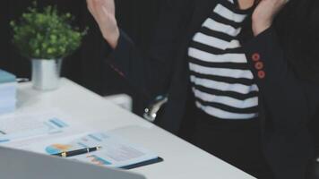 asiatique femme entrepreneur occupé avec sa travail dans le bureau. Jeune asiatique femme travail sur bureau portable téléphone tandis que Planification ventes, recherche ou financier stratégie dans entreprise video