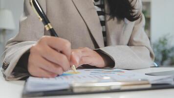 femme d'affaires asiatique utilisant un ordinateur portable et travaillant au bureau avec un document de calculatrice sur le bureau, faisant la planification en analysant le rapport financier, l'investissement dans le plan d'affaires, le concept d'analyse financière. video