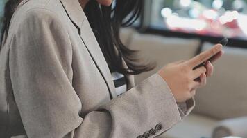 Asian woman entrepreneur busy with her work in the office. Young Asian woman work on desk laptop phone while planning sales, research or financial strategy in company video