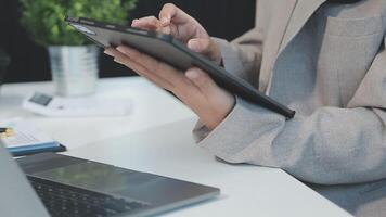 Asian Businesswoman Using laptop computer and working at office with calculator document on desk, doing planning analyzing the financial report, business plan investment, finance analysis concept. video
