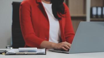 Asian Businesswoman Using laptop computer and working at office with calculator document on desk, doing planning analyzing the financial report, business plan investment, finance analysis concept. video
