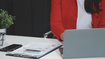 Asian Businesswoman Using laptop computer and working at office with calculator document on desk, doing planning analyzing the financial report, business plan investment, finance analysis concept. video
